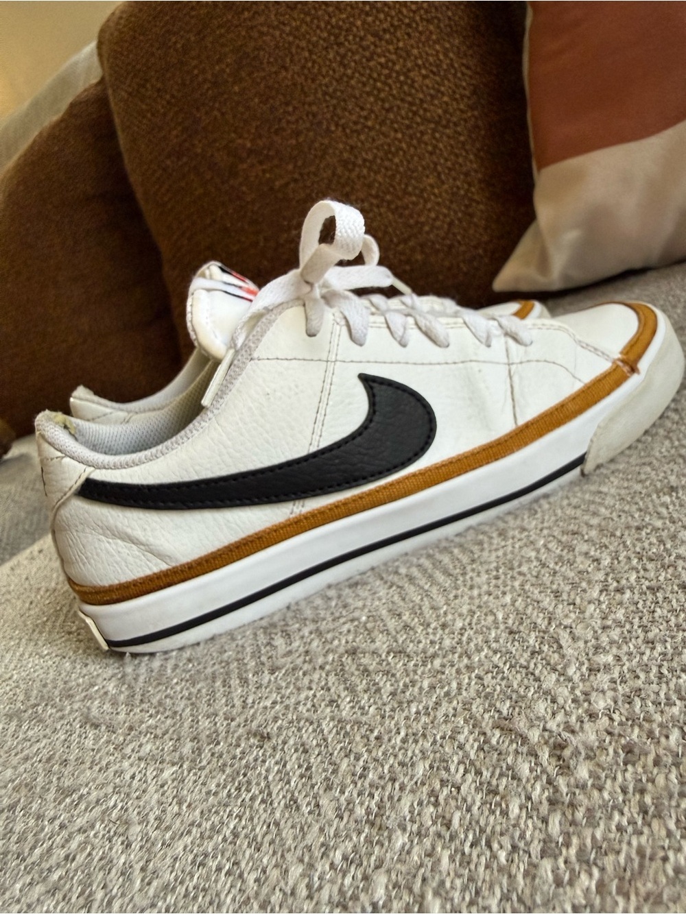 Nike women’s White Leather Low-Top Sneakers with Black Swoosh and Brown Accent